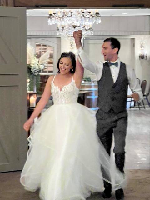 Rachel and Mitch Warren walk into their wedding reception.